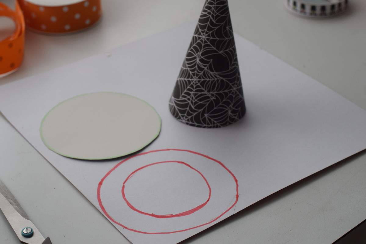 cutting circles in paper for witch hat 