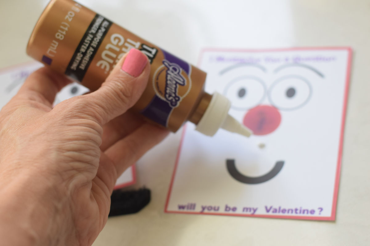gluing mustache to Valentine's Day card 