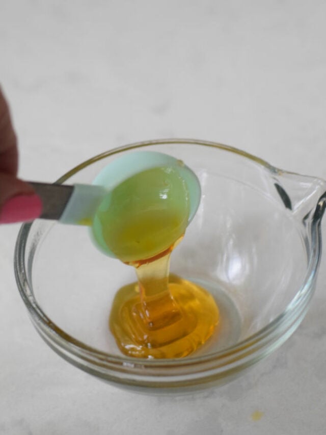 pouring honey from measuring spoon