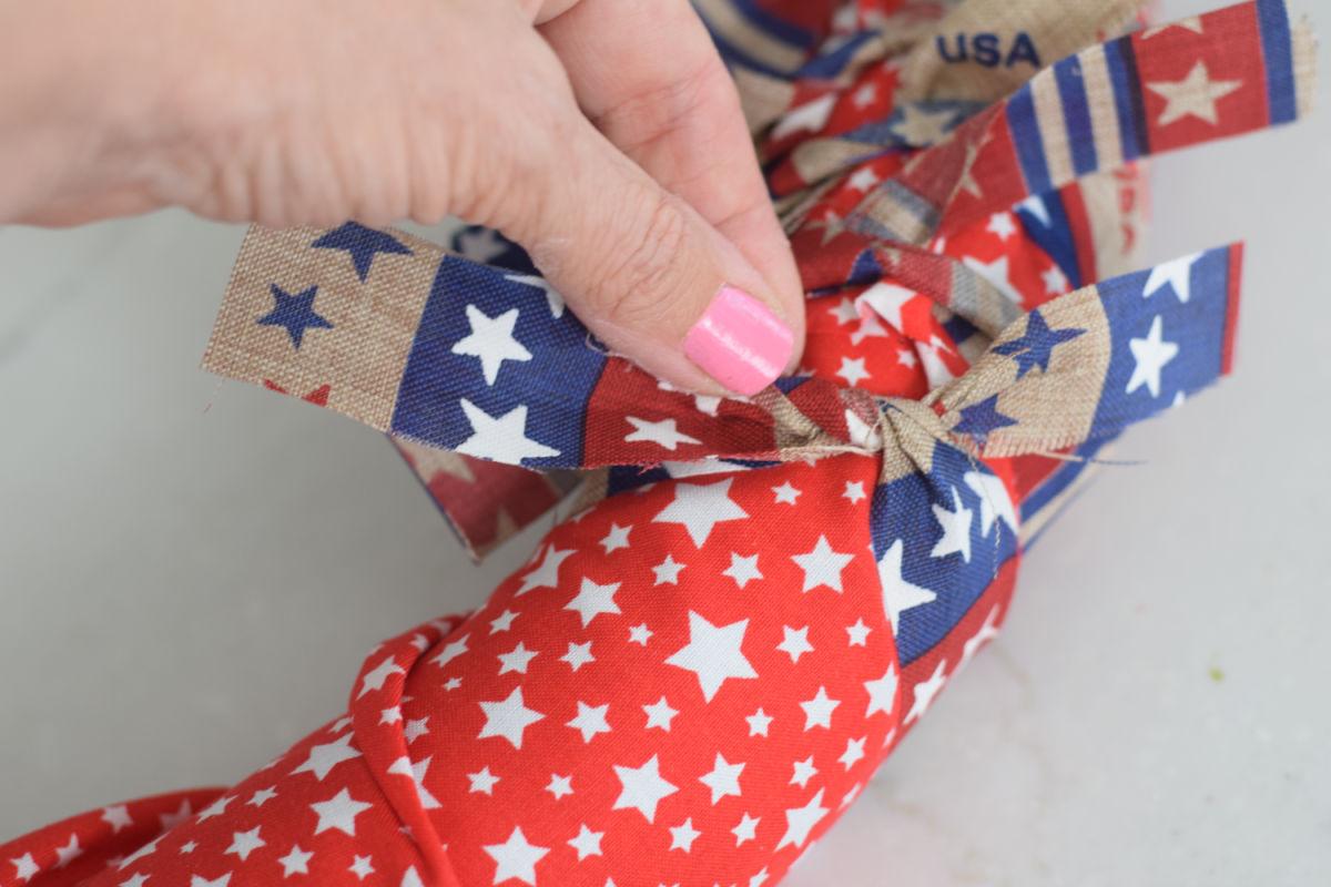 tying ribbon rags around a pool noodle wreath 