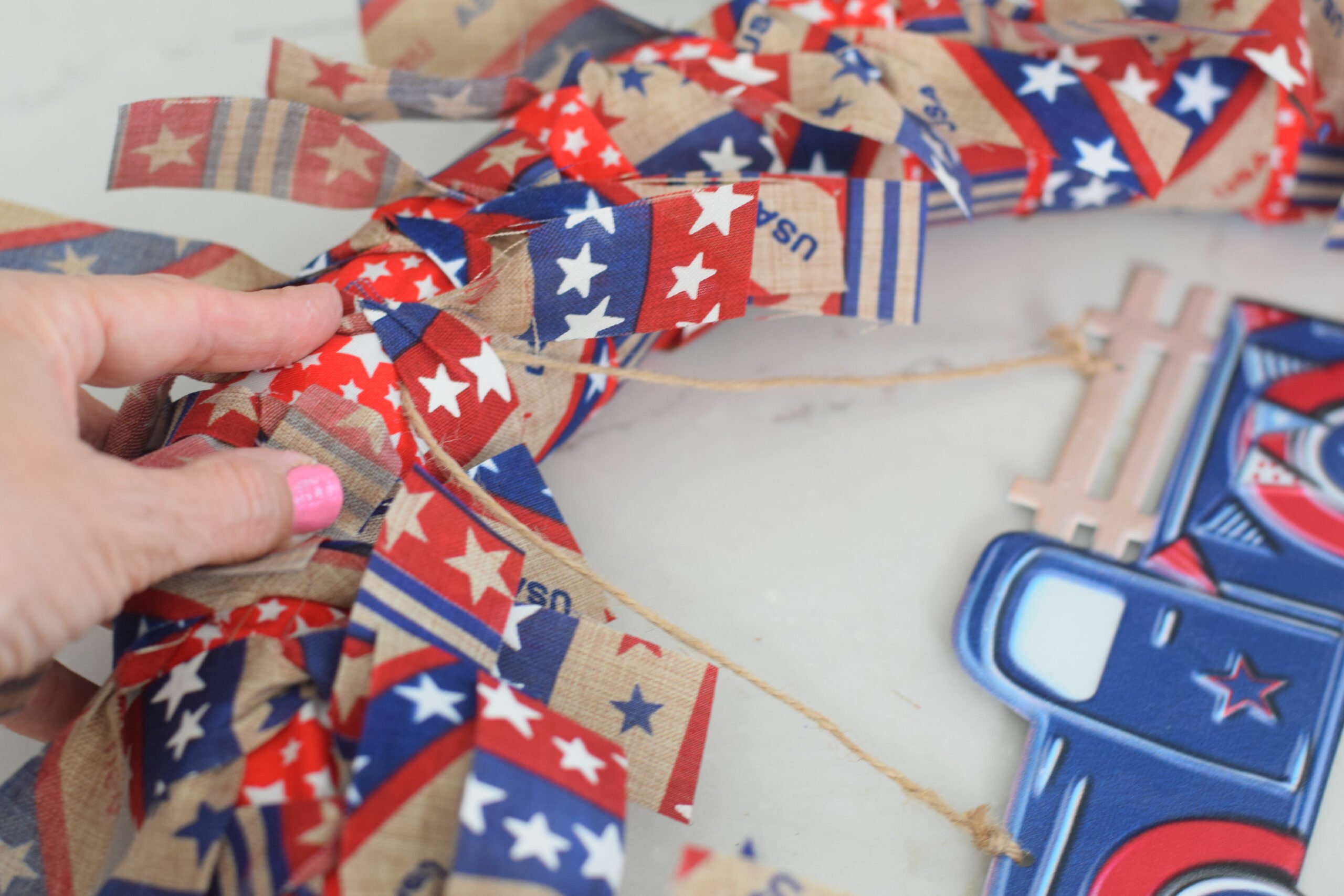 tying ribbon rags around a pool noodle wreath 
