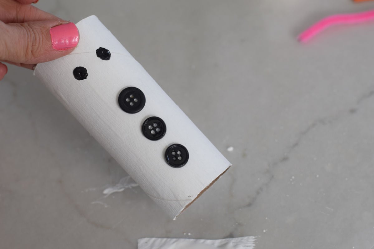 adding eyes and buttons to toilet paper tube snowman 