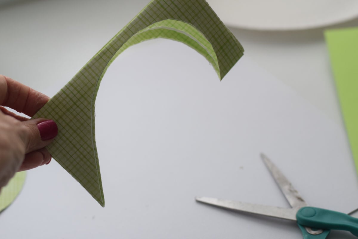 cutting heart out of green paper 
