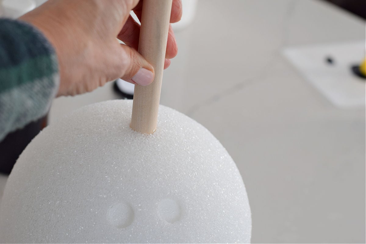 pushing a dowel into foam ball to make a bowling ball