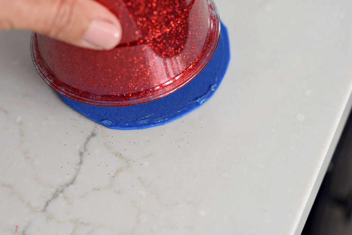 attaching glittered plastic cup to blue foam base for Uncle Sam hat