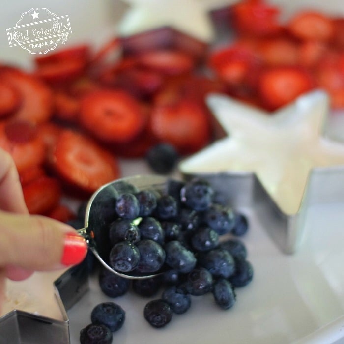 Filling a Patriotic Fruit Tray with Fresh Fruit