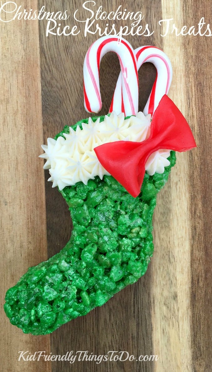 green Rice Krispie Treat Stocking with red candy bow and candy canes inside.
