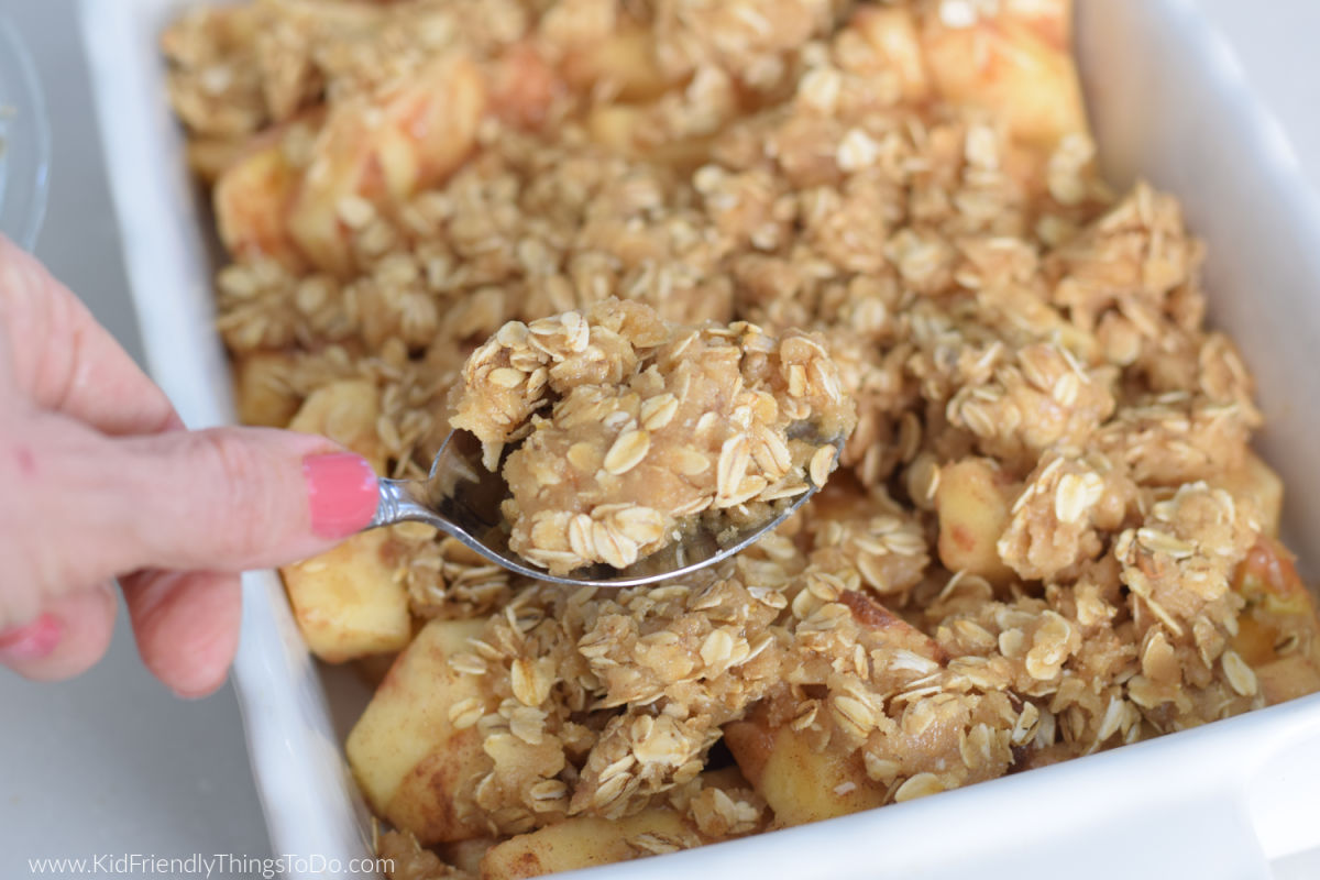 spooning crisp topping over apples