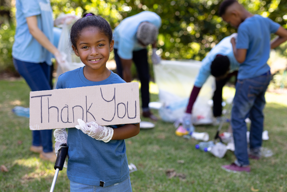 child with a thank you sign