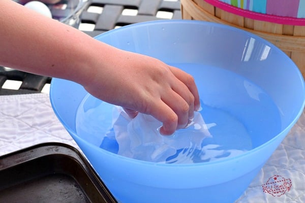 Placing Cotton Fabric in Water before Dying Easter Eggs with food coloring