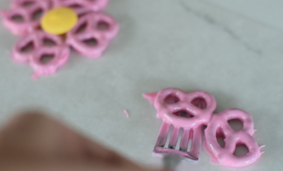 making pretzel flowers - setting pretzels down on wax paper 