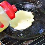 Make ahead pancake batter into iron skillet for camping breakfast