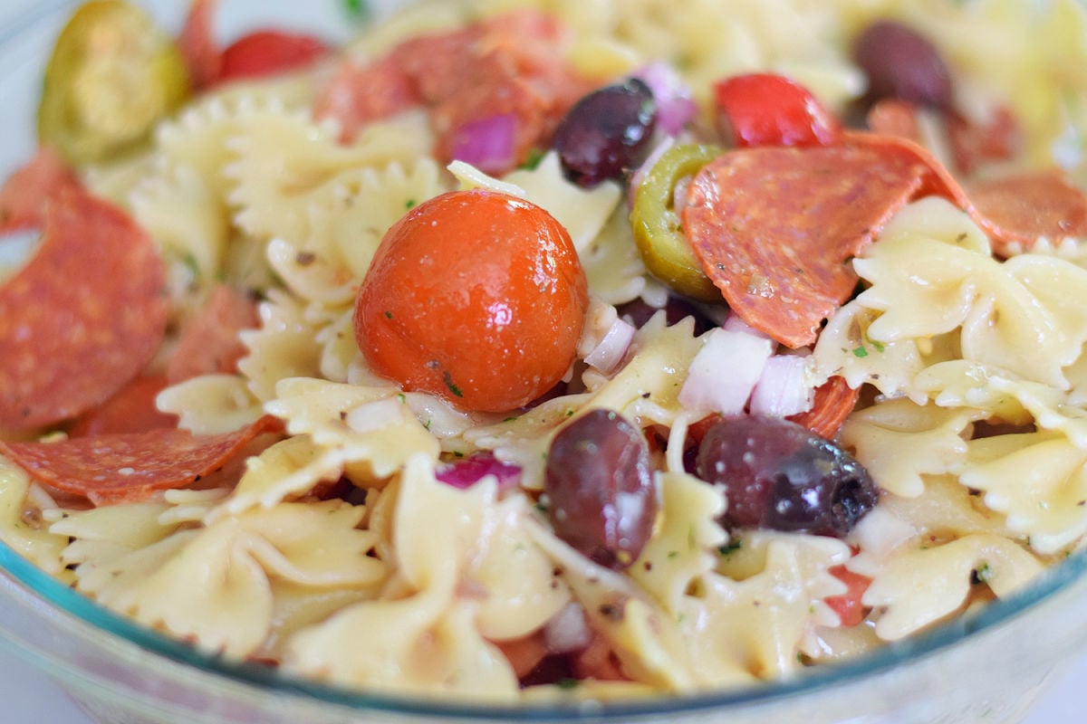 Greek pasta salad recipe with farfalle pasta, feta, pepperoni, olives, and Greek vinaigrette