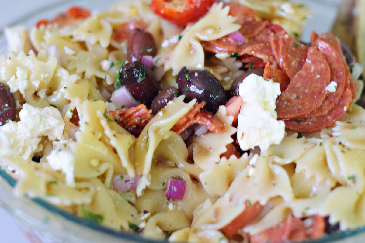 Easy Greek pasta salad with bow tie pasta, feta cheese, Kalamata olives, and pepperoni