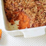 sweet potato casserole with scoop out and a coconut pecan crunch topping