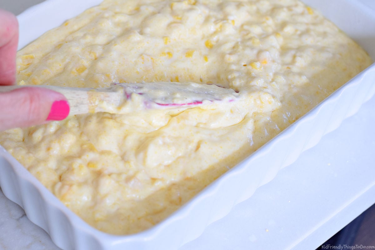 spreading cornbread casserole in pan