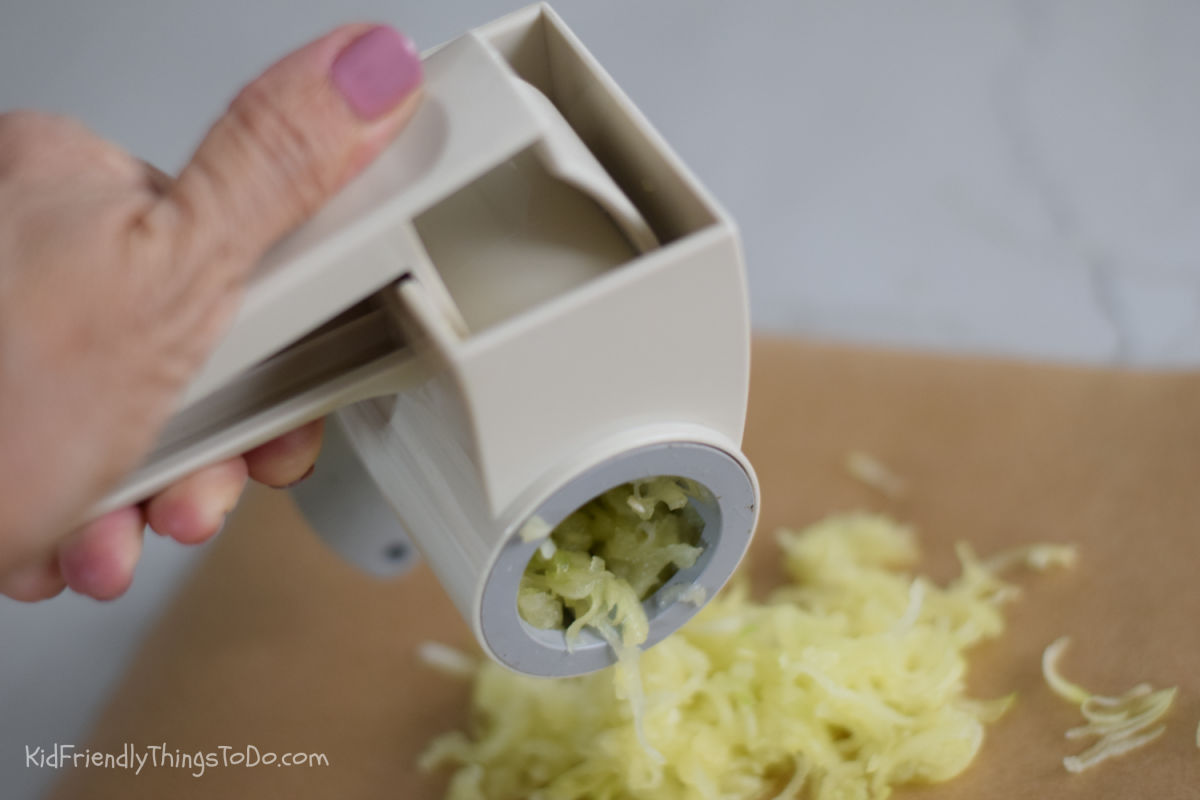 Peeled zucchini being grated for zucchini brownies