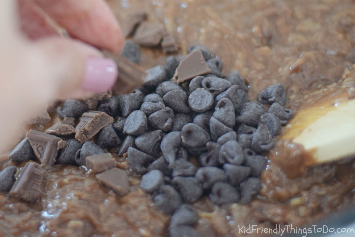 Chocolate chips and Hershey chocolate chunks being added to zucchini brownie batter