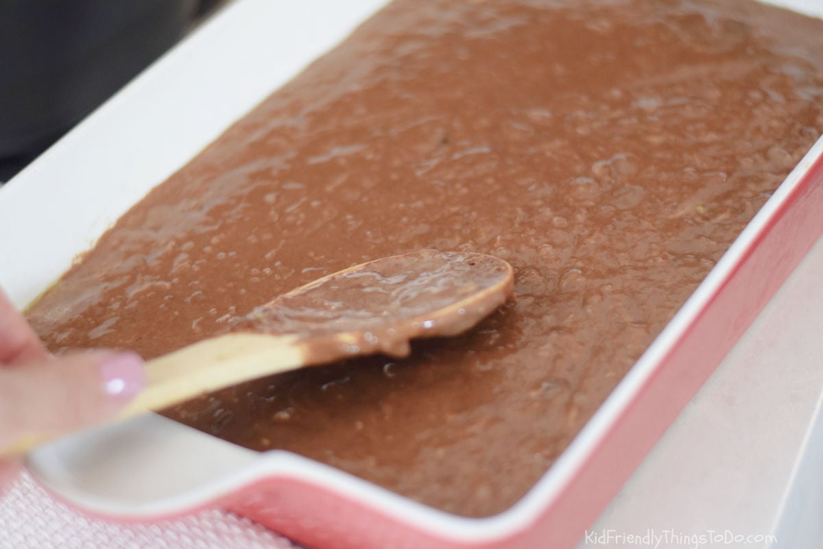 Chocolate zucchini brownie batter spread into a 9x13-inch baking pan