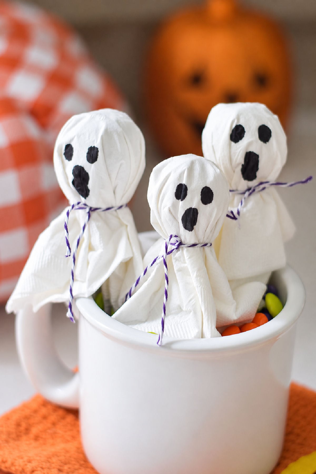 lollipop ghosts in a cup made from lollipop and a napkin