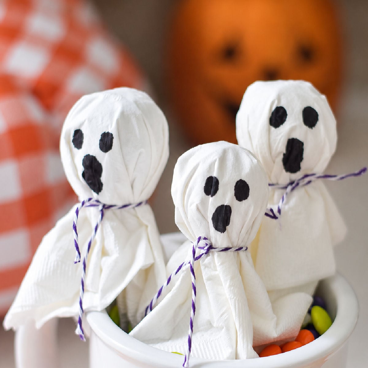 lollipop ghosts in a cup made from lollipop and a napkin