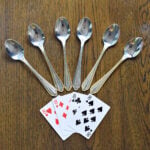 Four of a kind with silver spoons arranged for the spoons card game