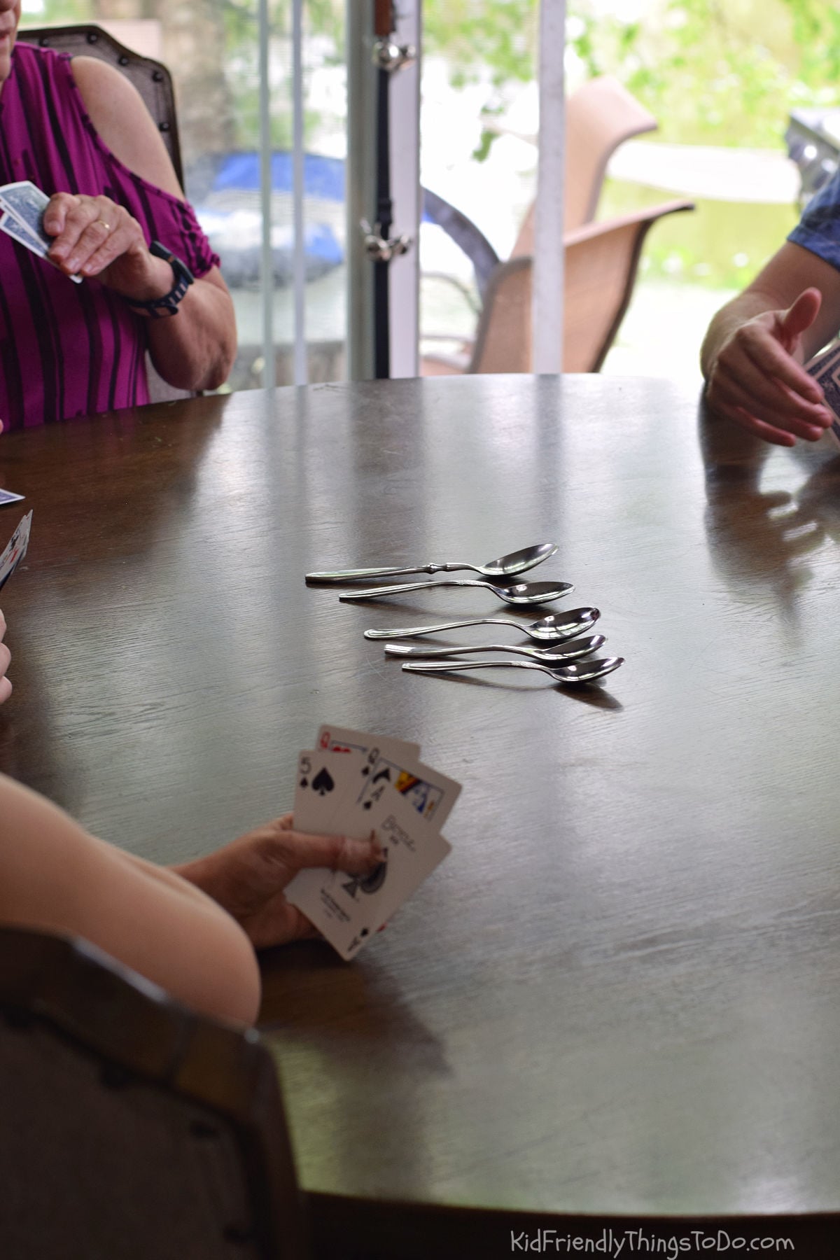 Players passing cards around the table during the spoons card game