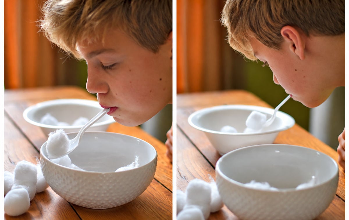 Boy scooping cotton balls with a plastic spoon for the Go Shovel the Snow Christmas Minute to Win It game.