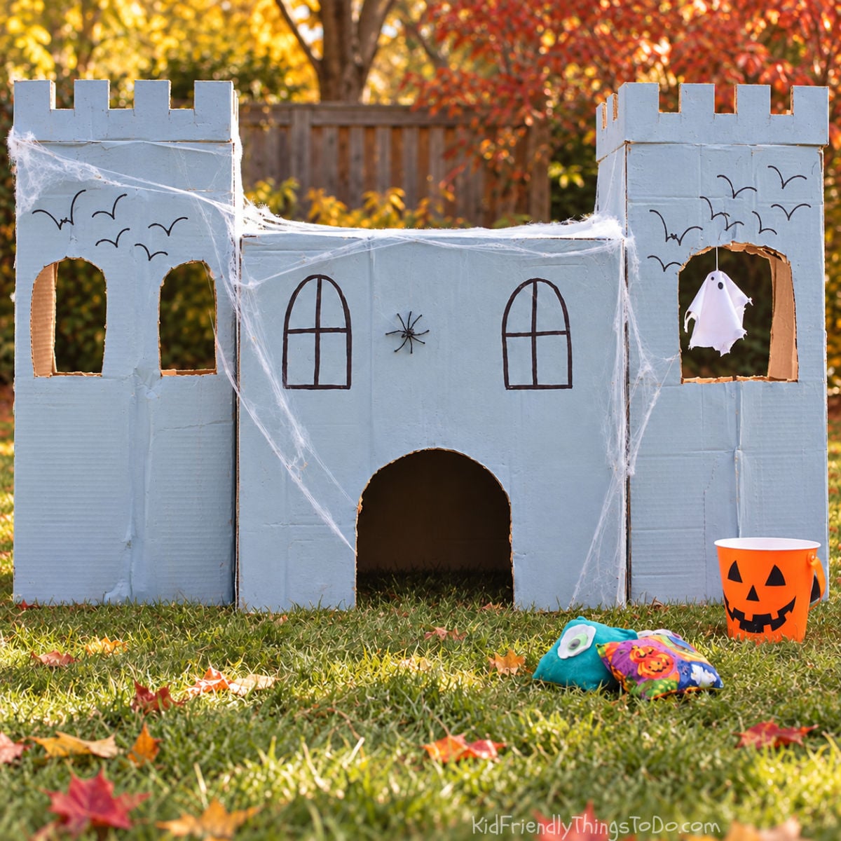 alt text for castle image before the extra decorations
Cardboard haunted castle bean bag toss painted gray, with arched window targets, a large doorway, and two side towers.