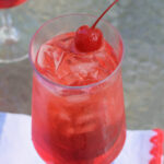 Classic Shirley Temple drink with ice and maraschino cherry