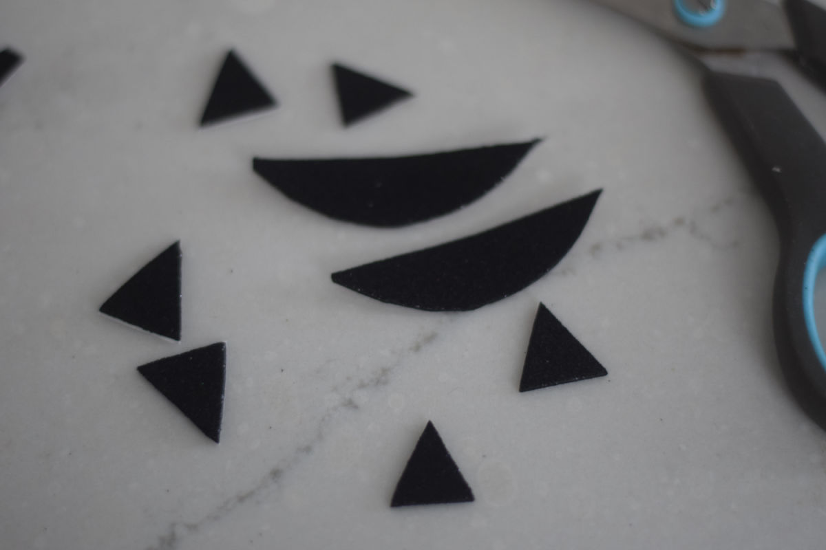 cutting out Jack-O-Lantern shapes from adhesive foam