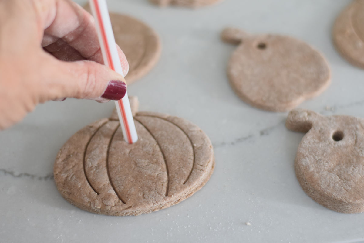 pushing a straw into salt dough ornaments 