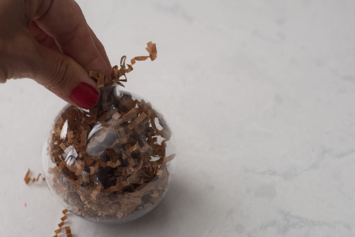 putting shredded paper into Rudolph ornament