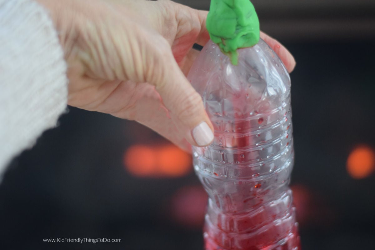 holding a homemade thermometer 