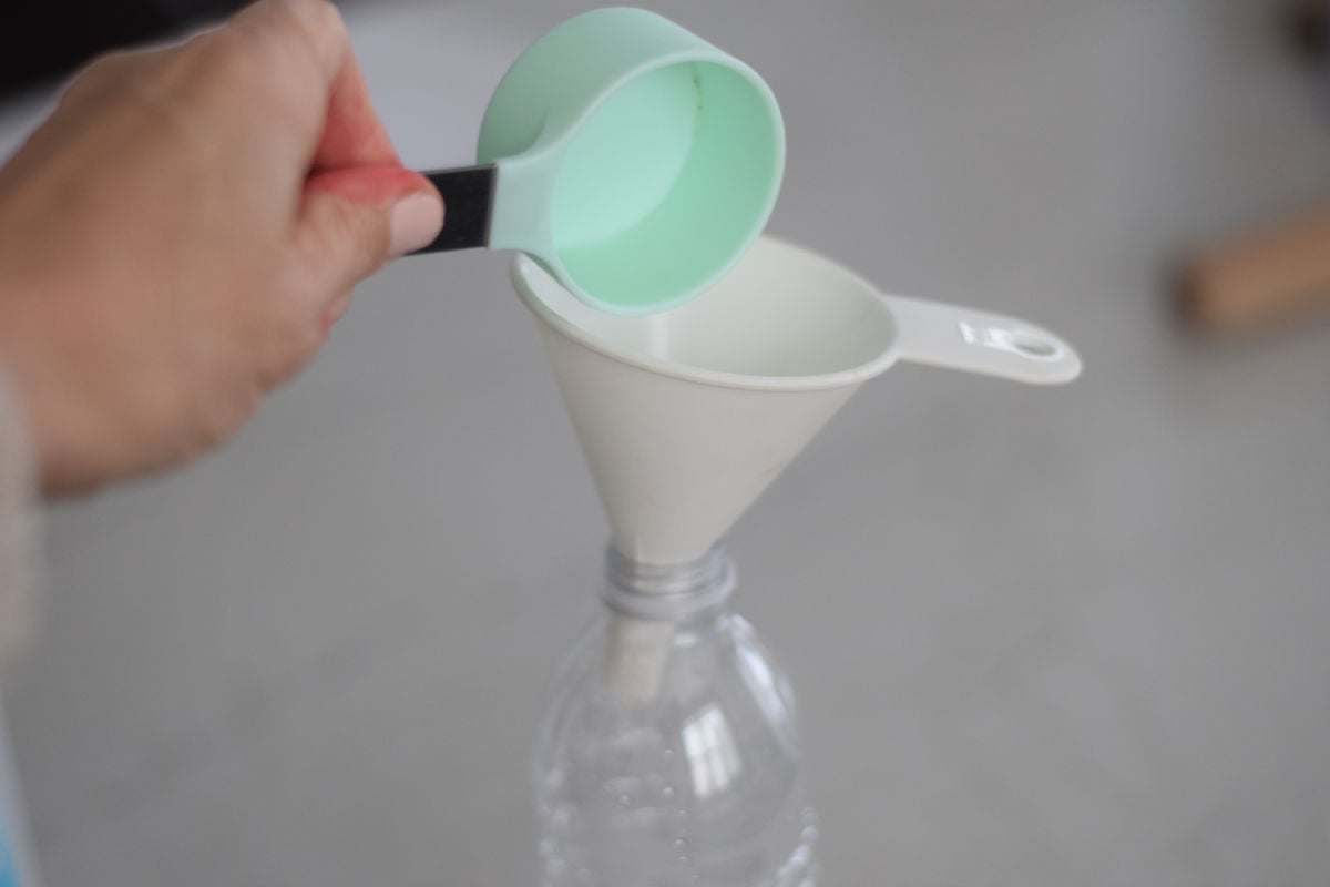 making a thermometer - pouring liquid into funnel 