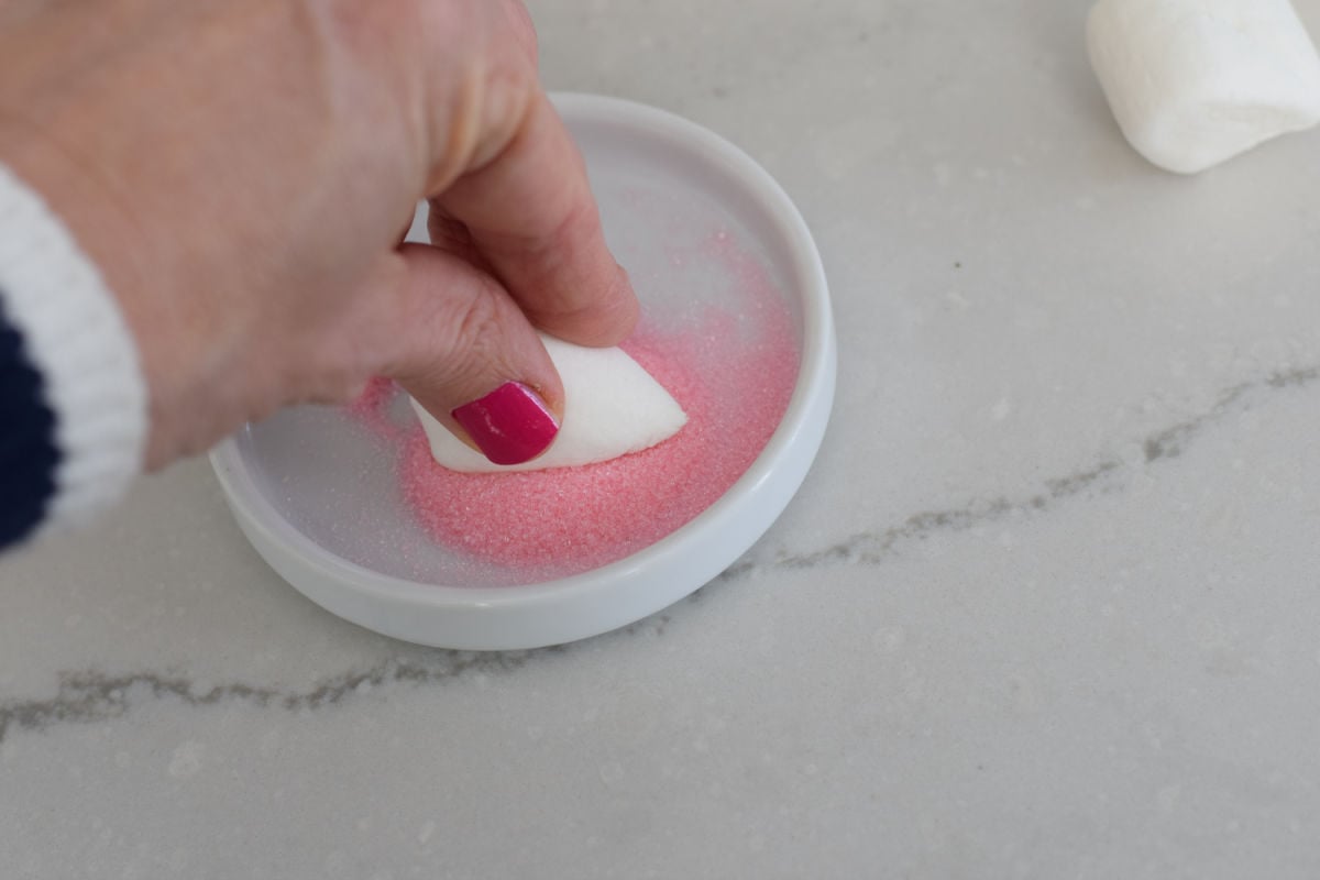 pushing marshmallows into sugar 