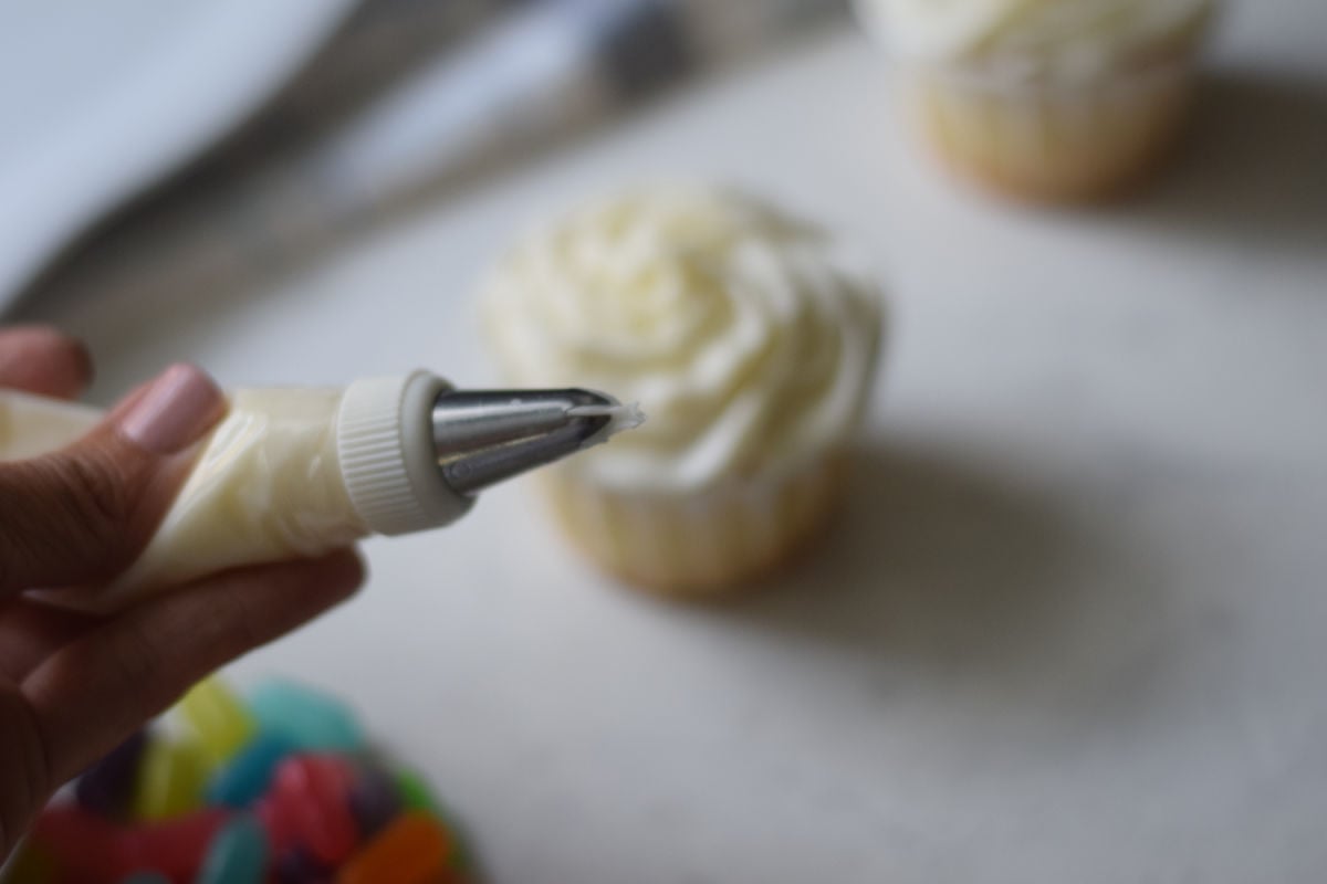 piping buttercream frosting onto cupcakes 