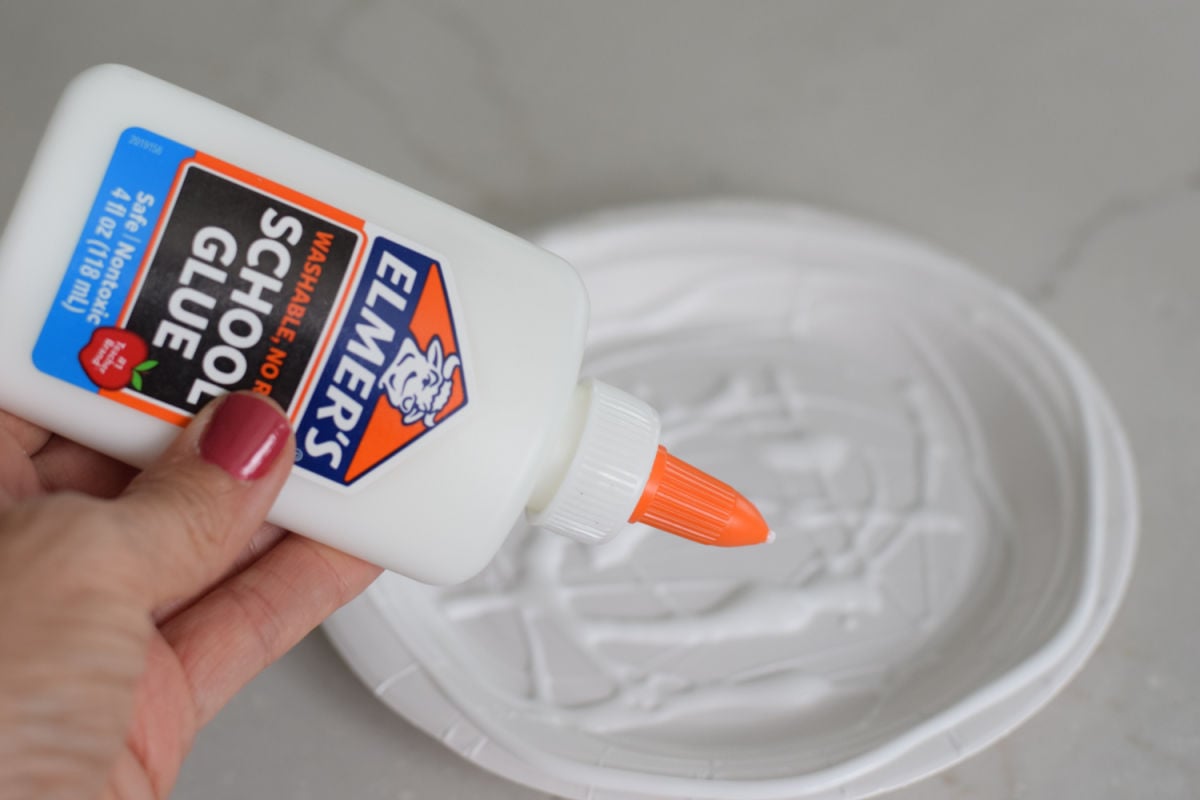 adding glue to a paper plate