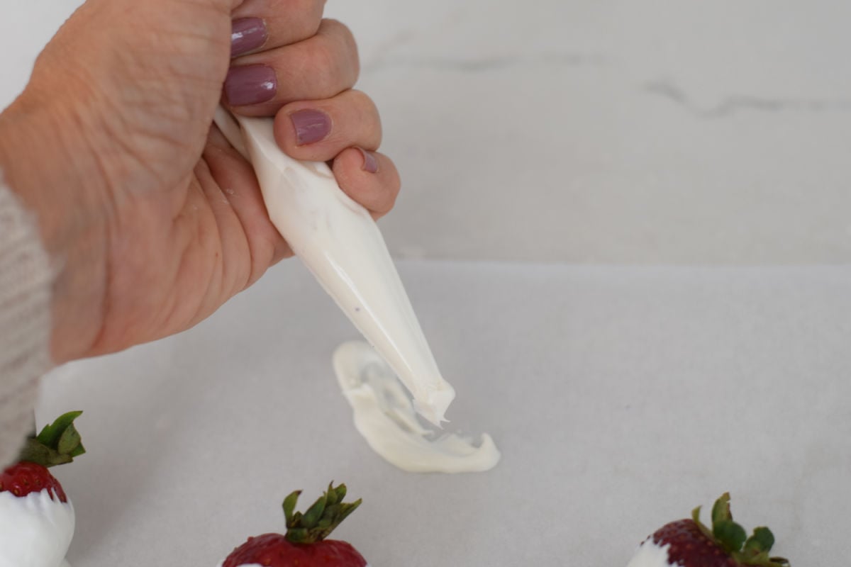 piping white chocolate for ghost strawberries 
