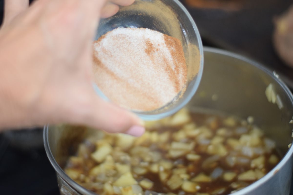 adding spices to apple chutney