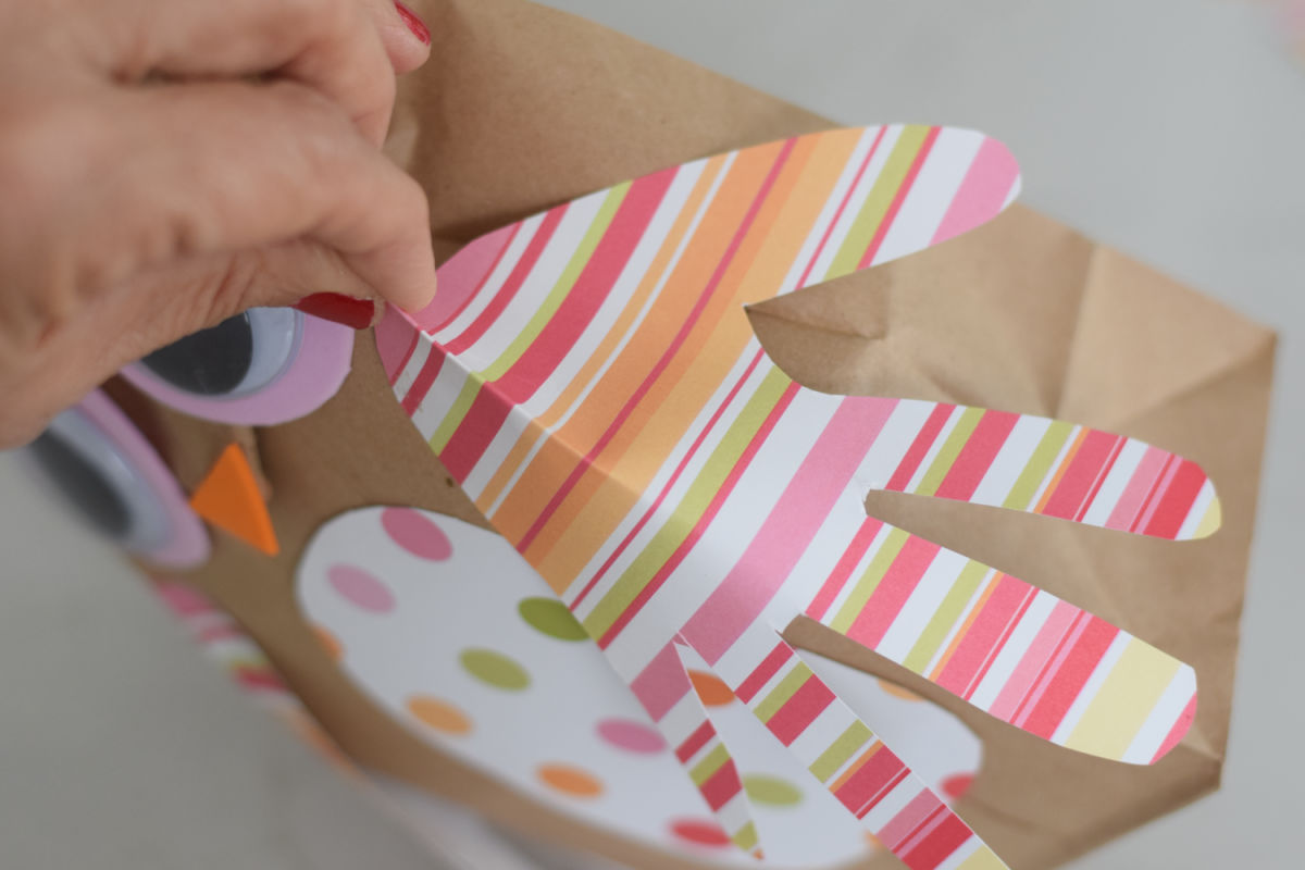 gluing handprint onto owl paper bag craft
