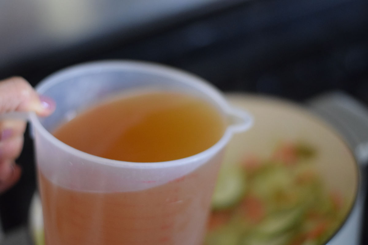 adding broth to soup