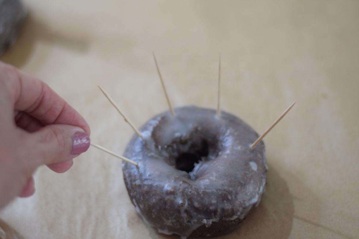 inserting toothpicks into donut
