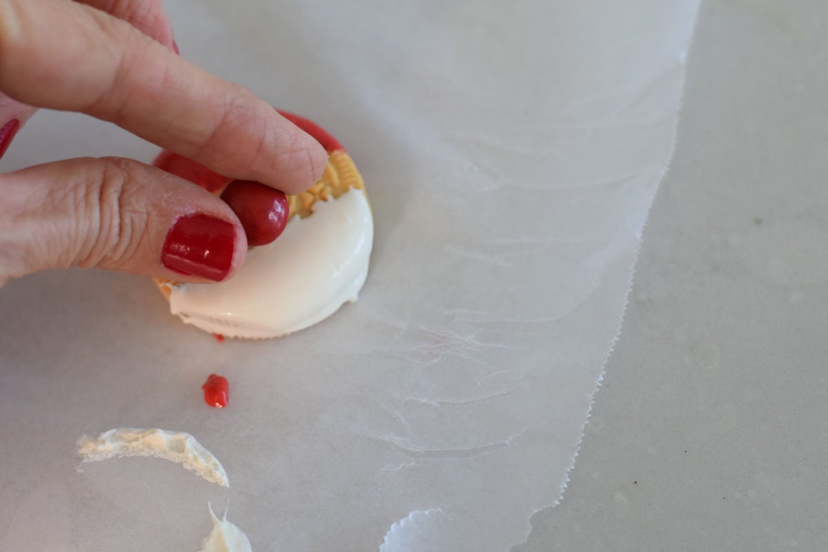 adding M&M to Santa cookie