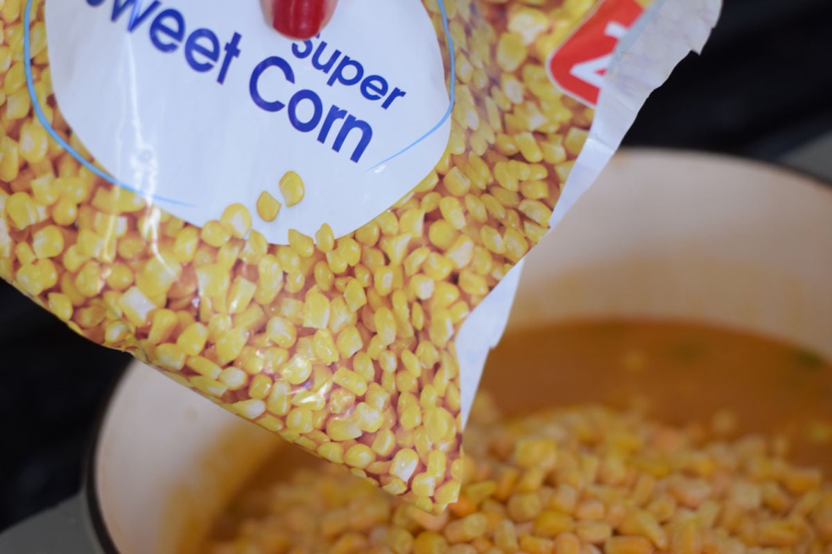 adding corn to soup