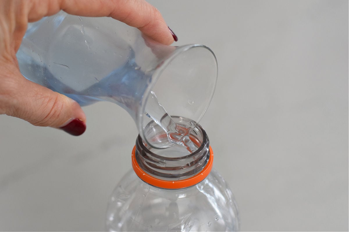pouring blue water into sensory bottle
