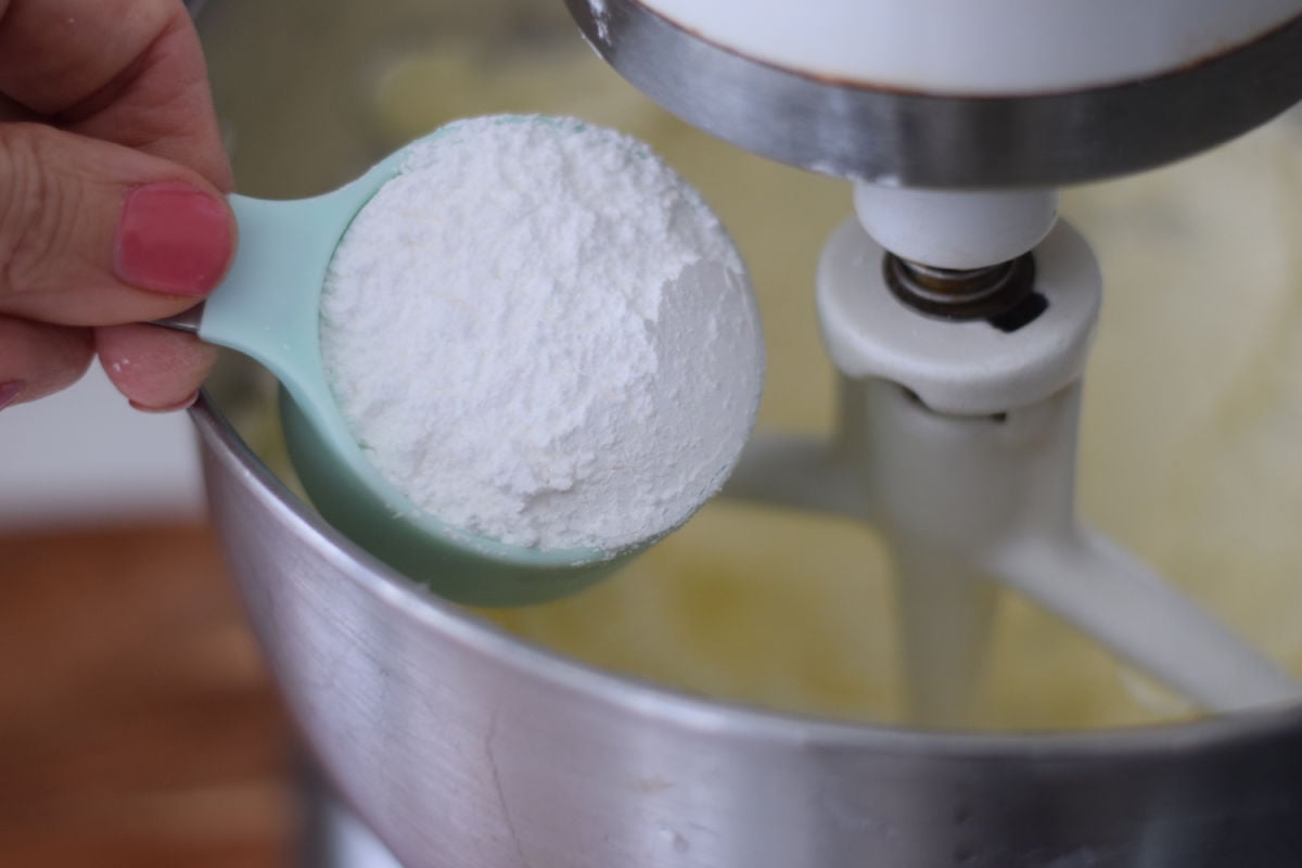 adding powdered sugar to mixer 