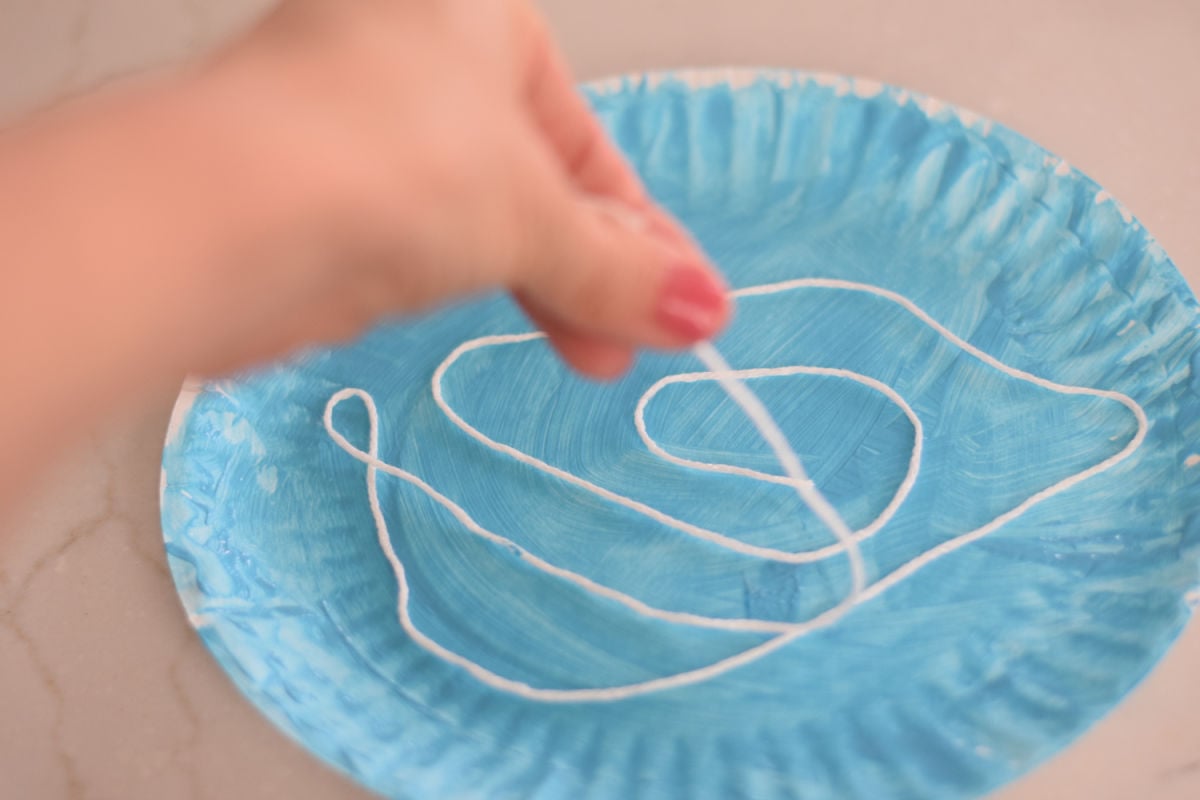 adding white yarn to ice skating craft 