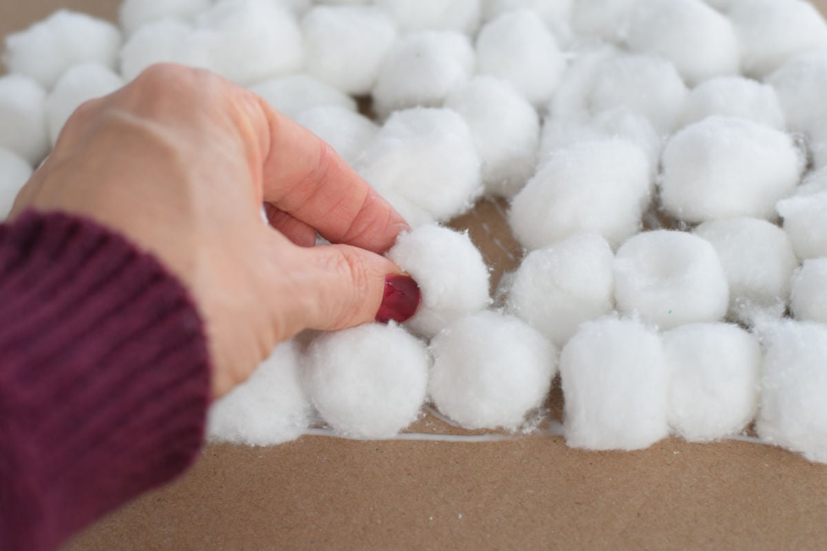 pressing cotton balls into glue