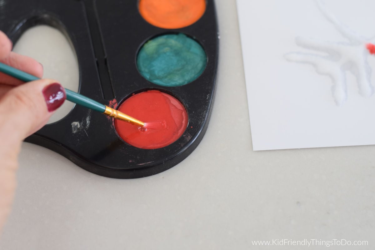 adding paint to paintbrush